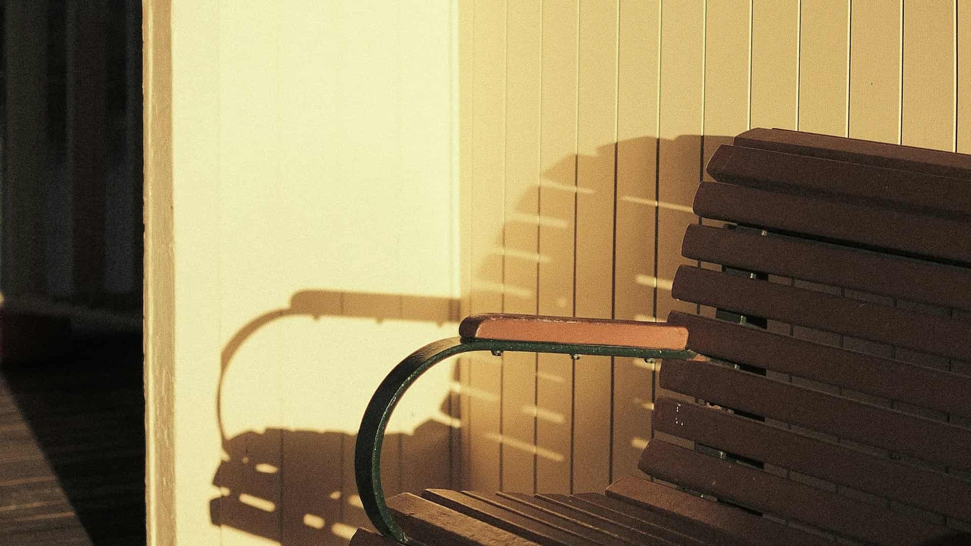 Un banco de madera bajo una luz cálida, apartado