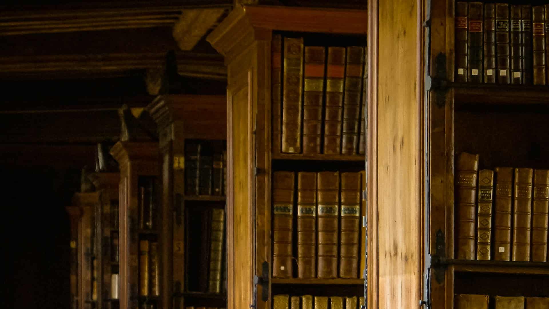 Estanterías de madera antiguas, llenas de libros encuadernados