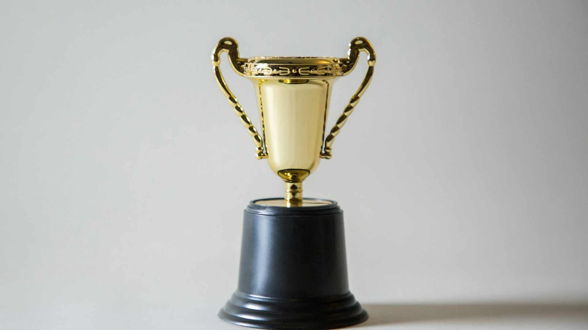 Uma pequena taça dourada sobre uma base preta