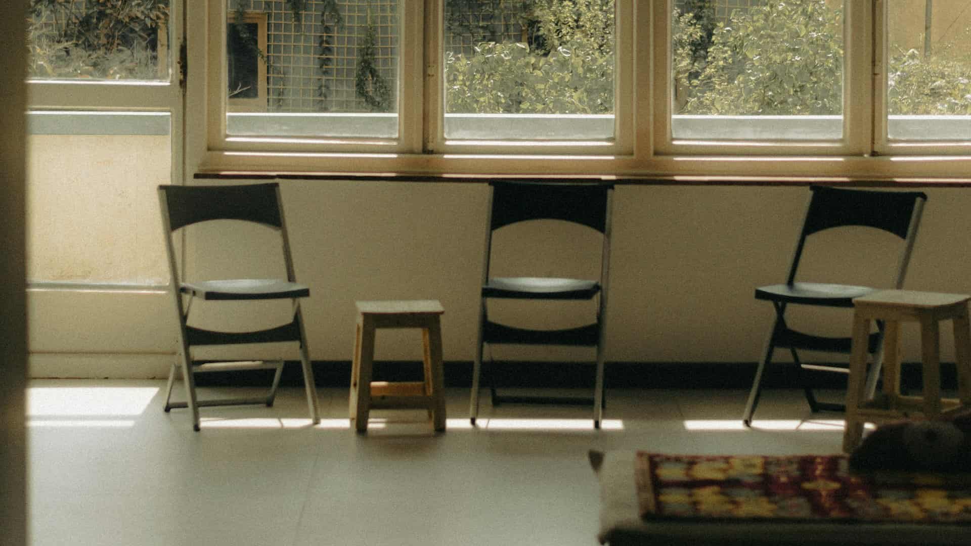 Empty chairs by a window in a quiet room