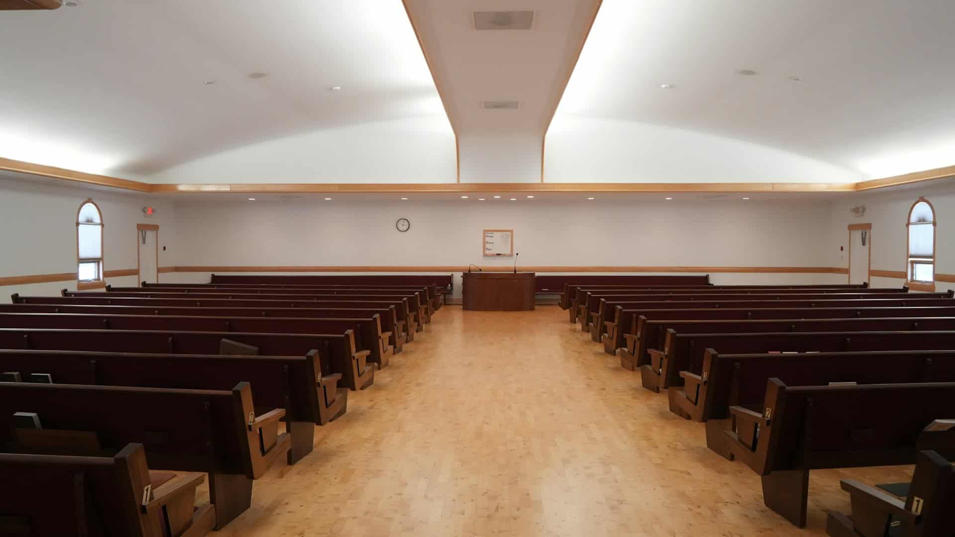 Una sala de culto luminosa, con su púlpito y sus bancos vacíos